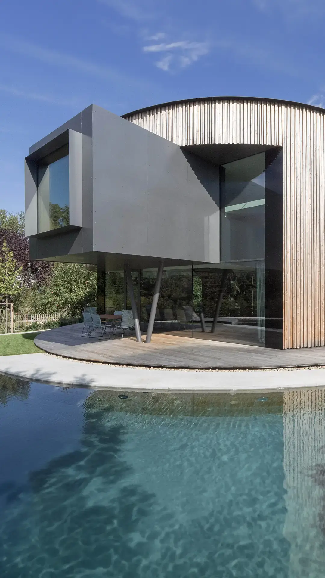 Drehhaus Kylie in Heuchelheim - Außenansicht mit reflektierender Wasseroberfläche, entworfen von Gronych+Dollega Architekten (mobil)