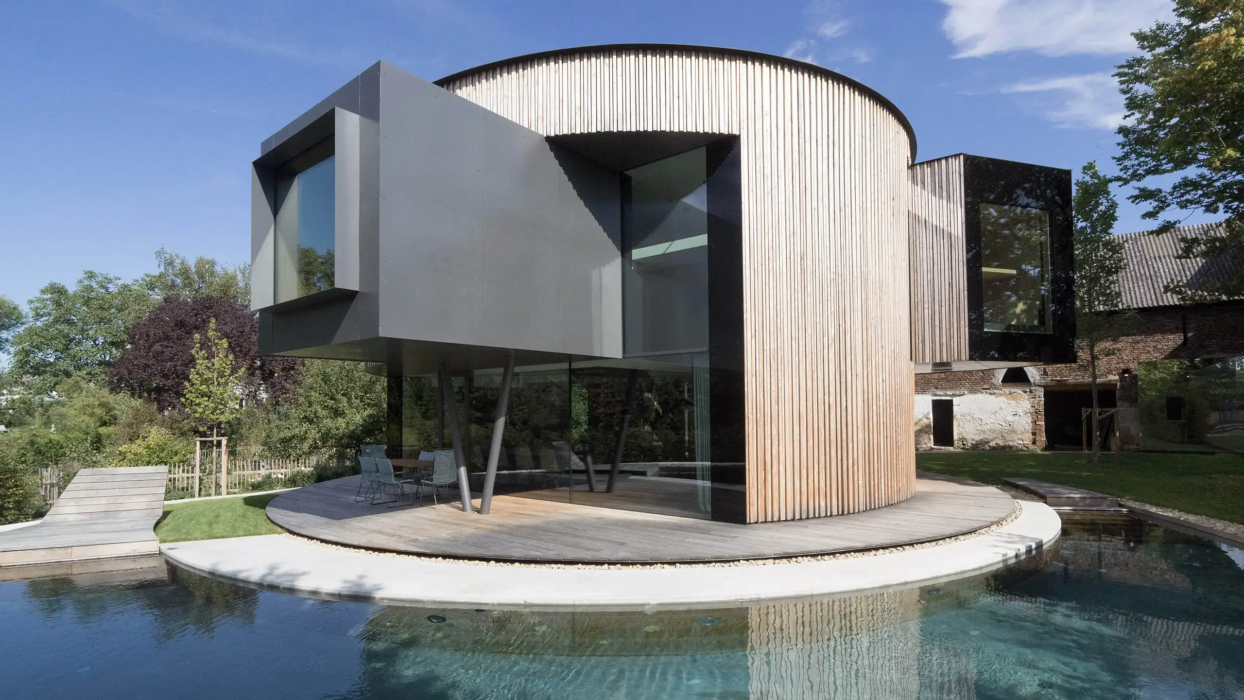 Drehhaus Kylie in Heuchelheim - Außenansicht mit reflektierender Wasserfläche, entworfen von Gronych+Dollega Architekten