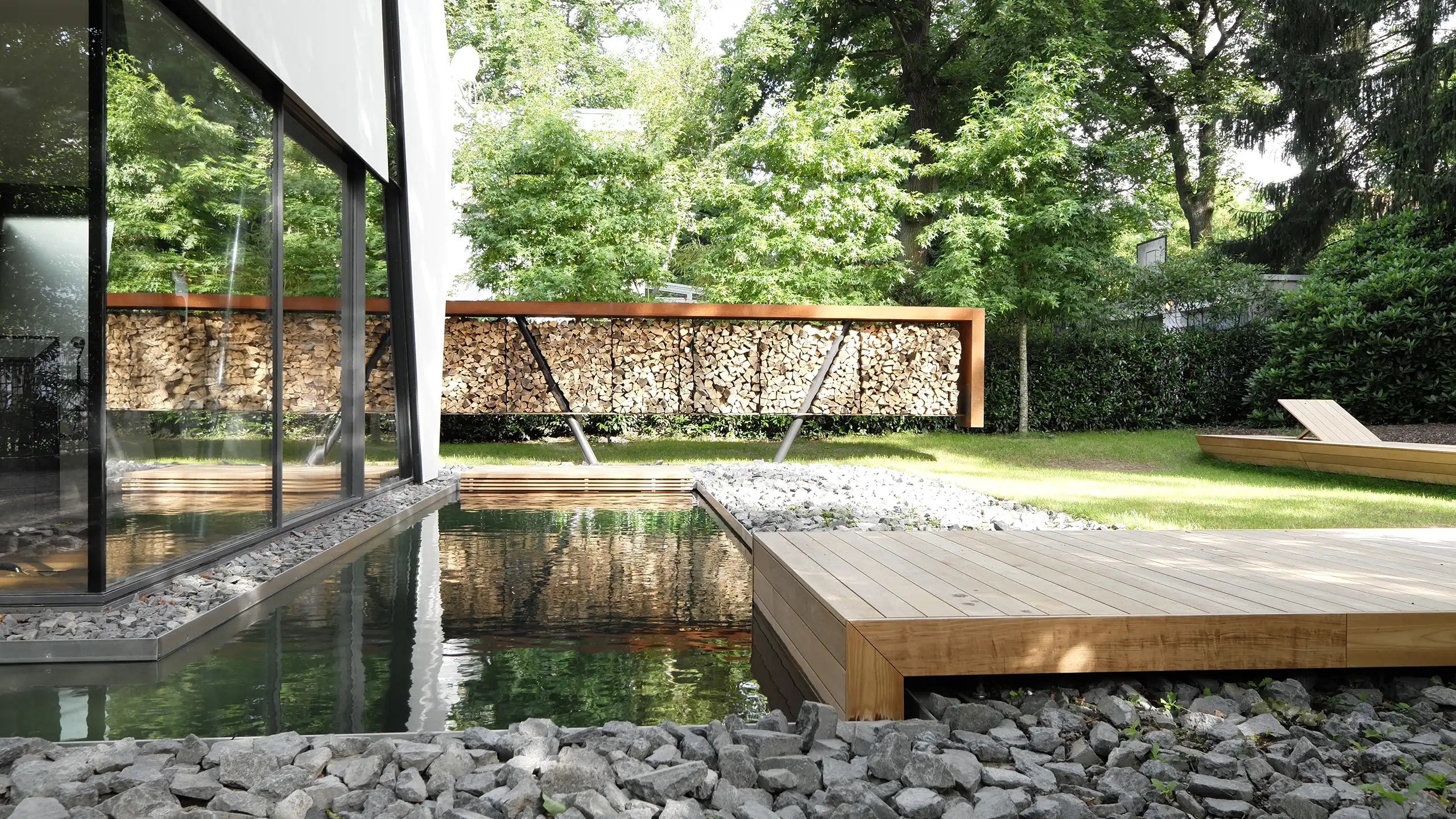 Villa im Hardtwald in Bad Homburg – Garten mit Wasserfläche bis an die Glasfassade und Teakterrasse