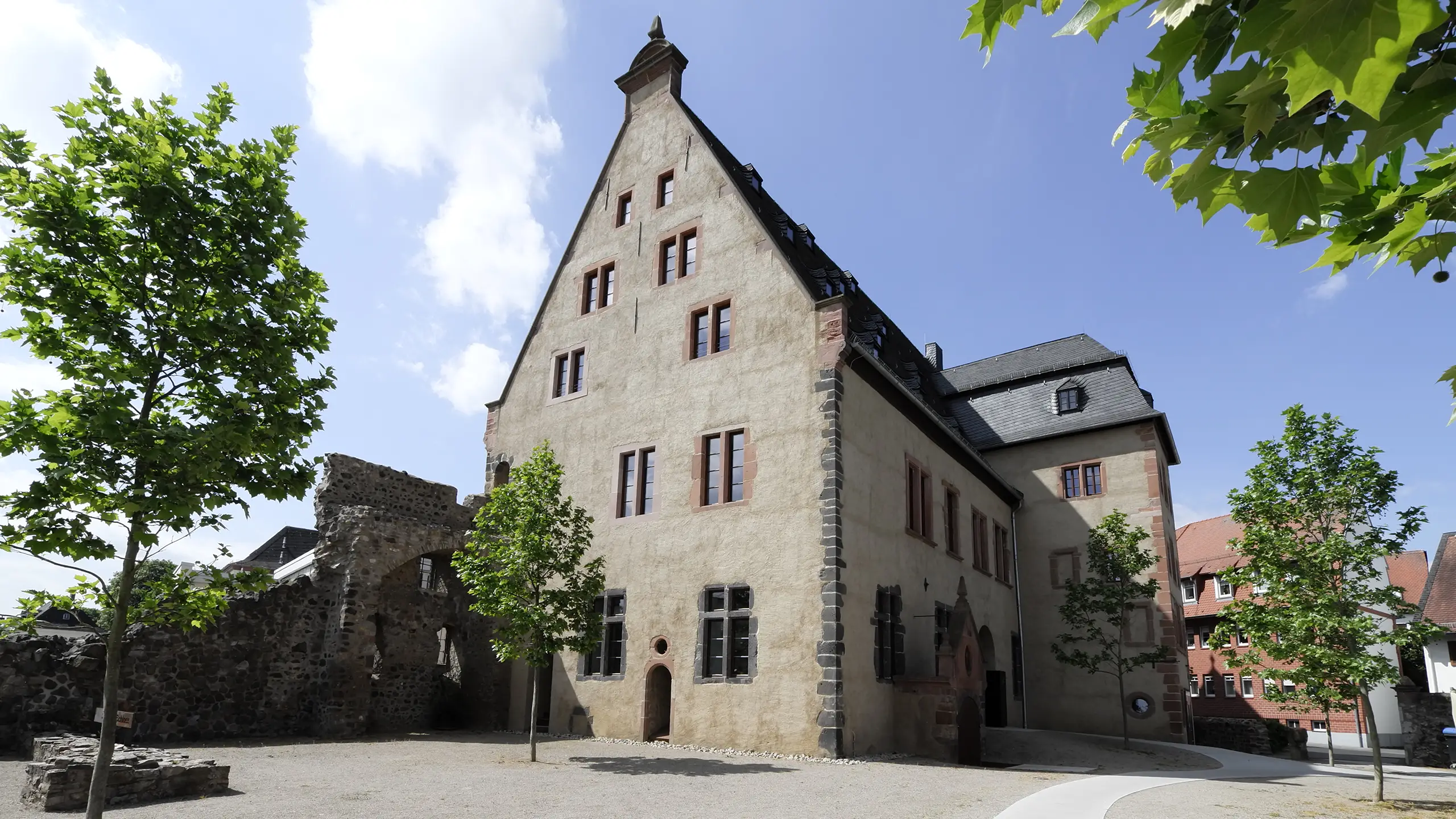 Solmser Schloss Butzbach – Giebelfassade mit freigelegten historischen Fensteröffnungen und Stadtmauerfragment