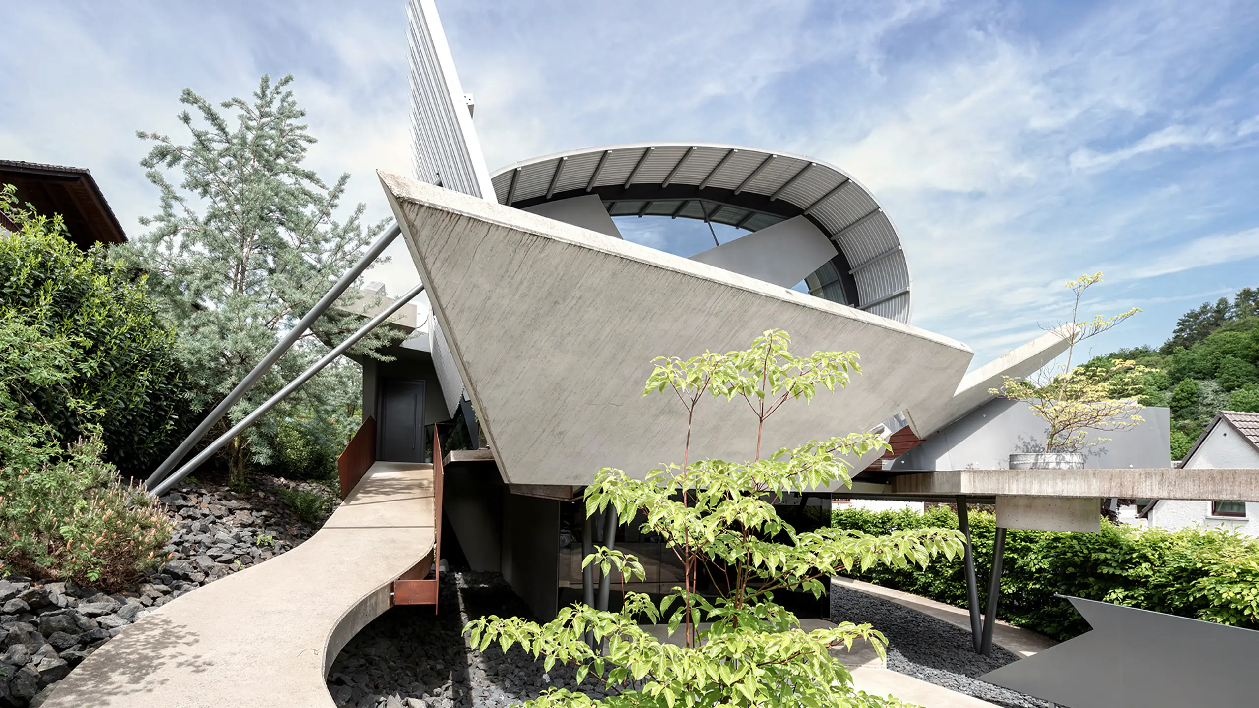 Haus des Markscheiders in Tiefenbach bei Wetzlar von Gronych + Dollega Architekten, Außenansicht mit skulpturalem Baukörper und geschwungener Betonrampe