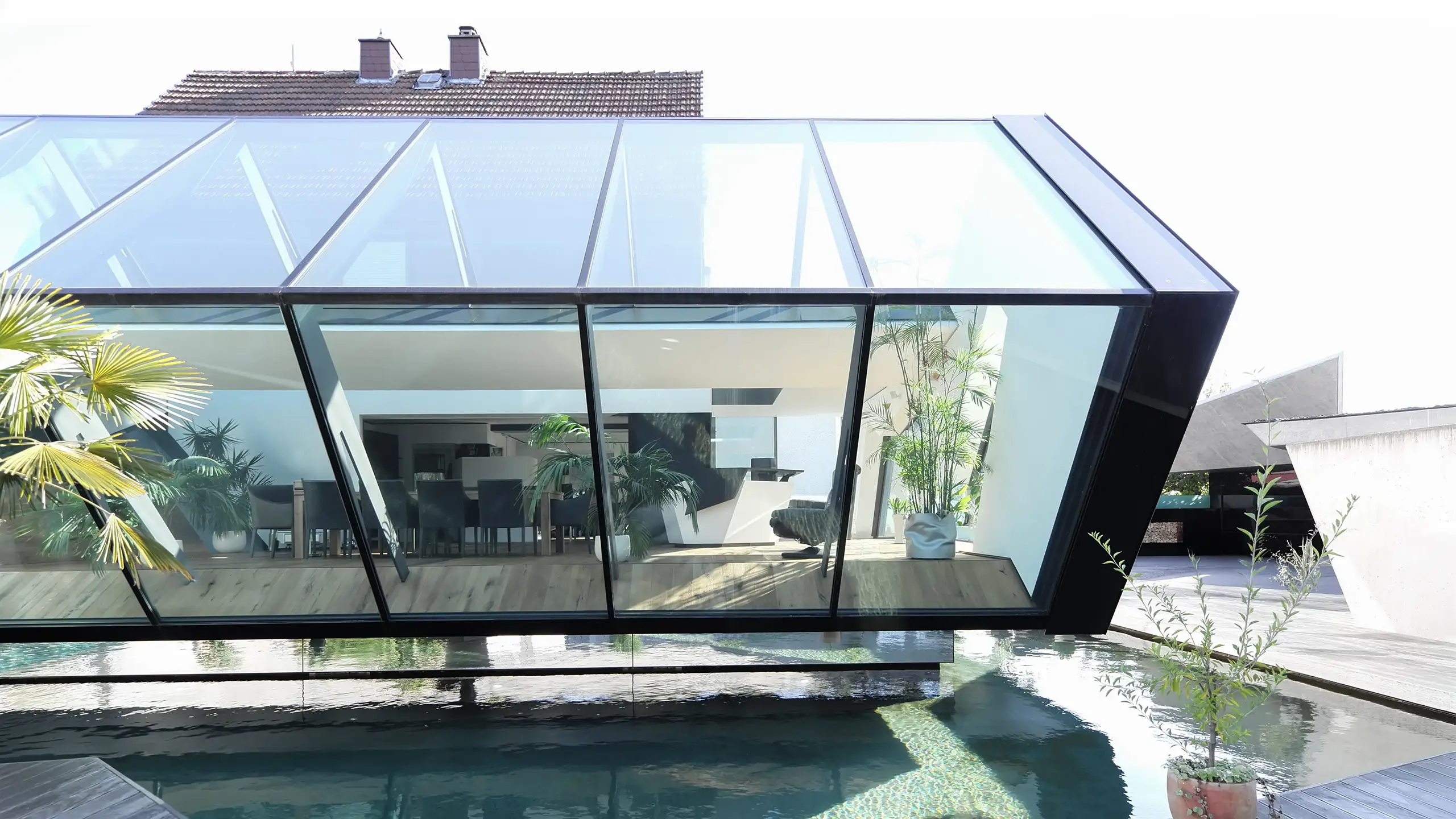 Wohnhaus N in Atzbach bei Wetzlar von Gronych + Dollega Architekten, Außenansicht mit schwebendem Glaskörper über Wasserfläche
