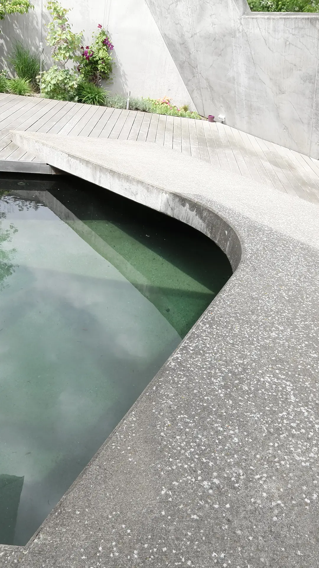 Vertikale Ansicht des Wohnhauses N in Atzbach bei Wetzlar mit Betonbrücke über der Wasserfläche im geschützten Hof