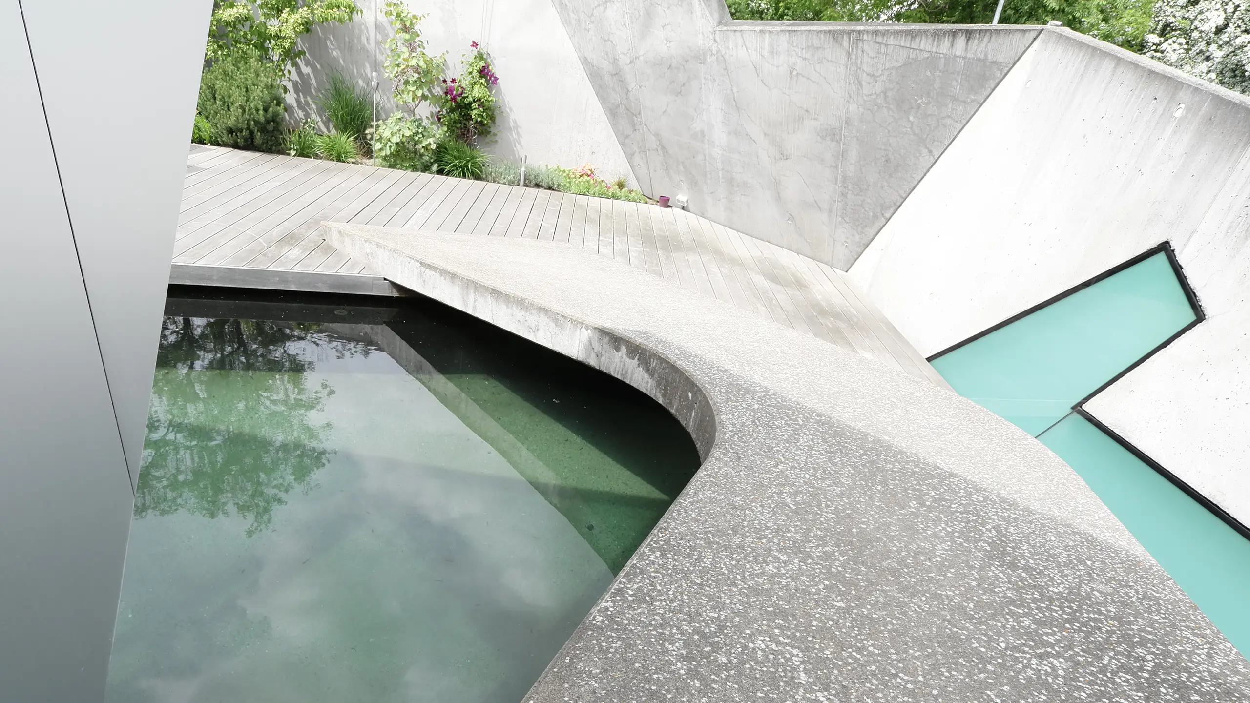 Wohnhaus N in Atzbach bei Wetzlar von Gronych + Dollega Architekten, Betonbrücke über Wasserfläche im geschützten Hof