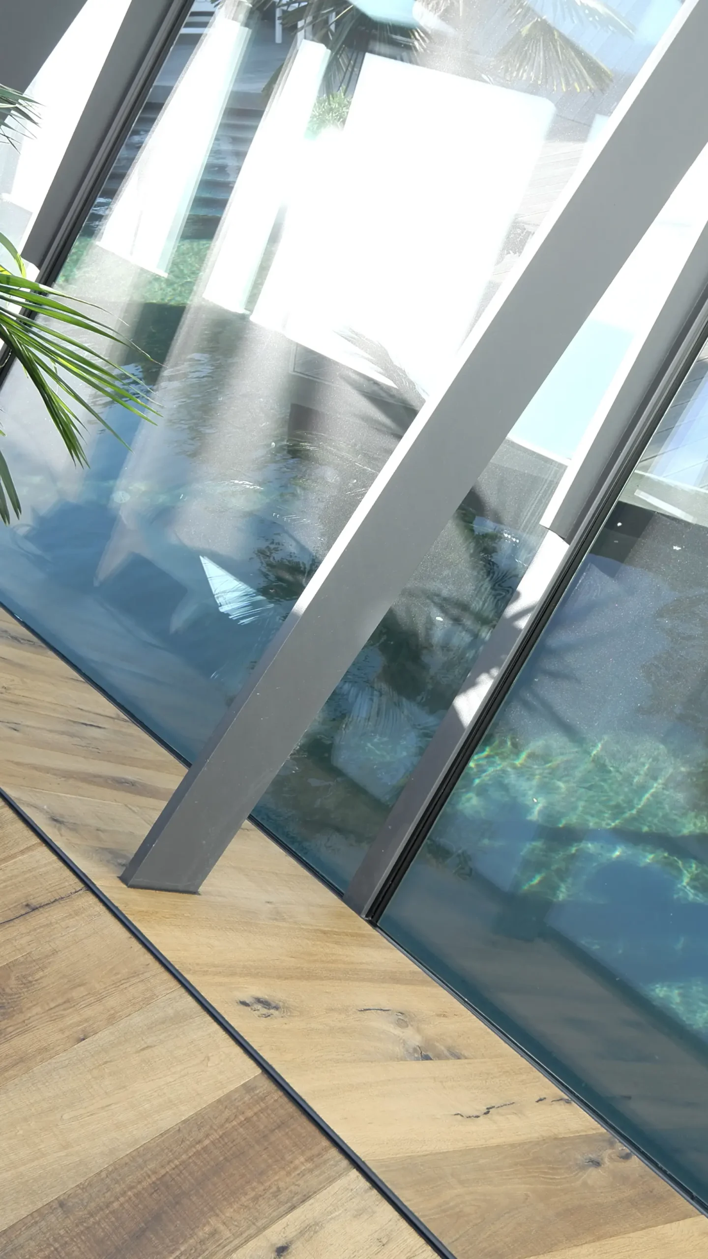 Vertikales Detail des Wohnhauses N in Atzbach bei Wetzlar mit Stahlprofil, Glasfläche, Holzfußboden und Wasserfläche