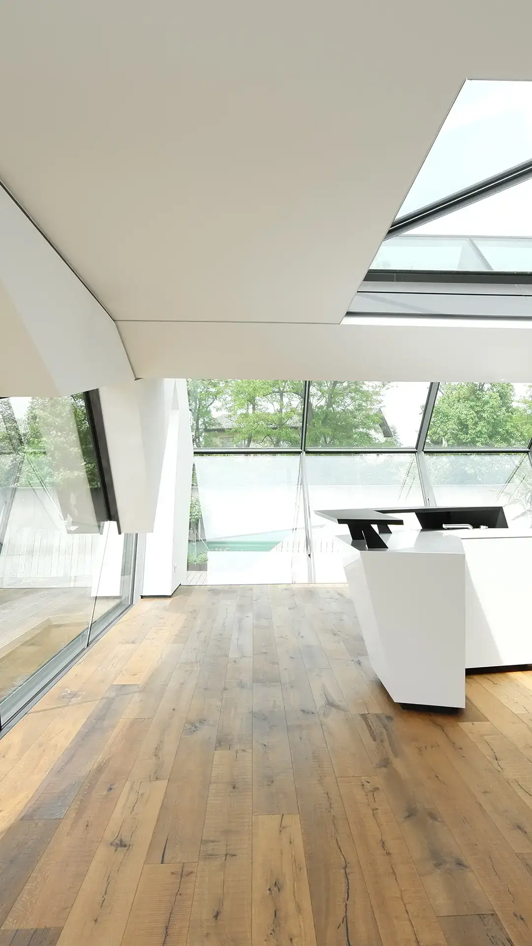 Vertikaler Innenraumausschnitt des Wohnhauses N in Atzbach bei Wetzlar mit Wohnraum, Küche, Holzfußboden, Glasdach und Blick nach außen